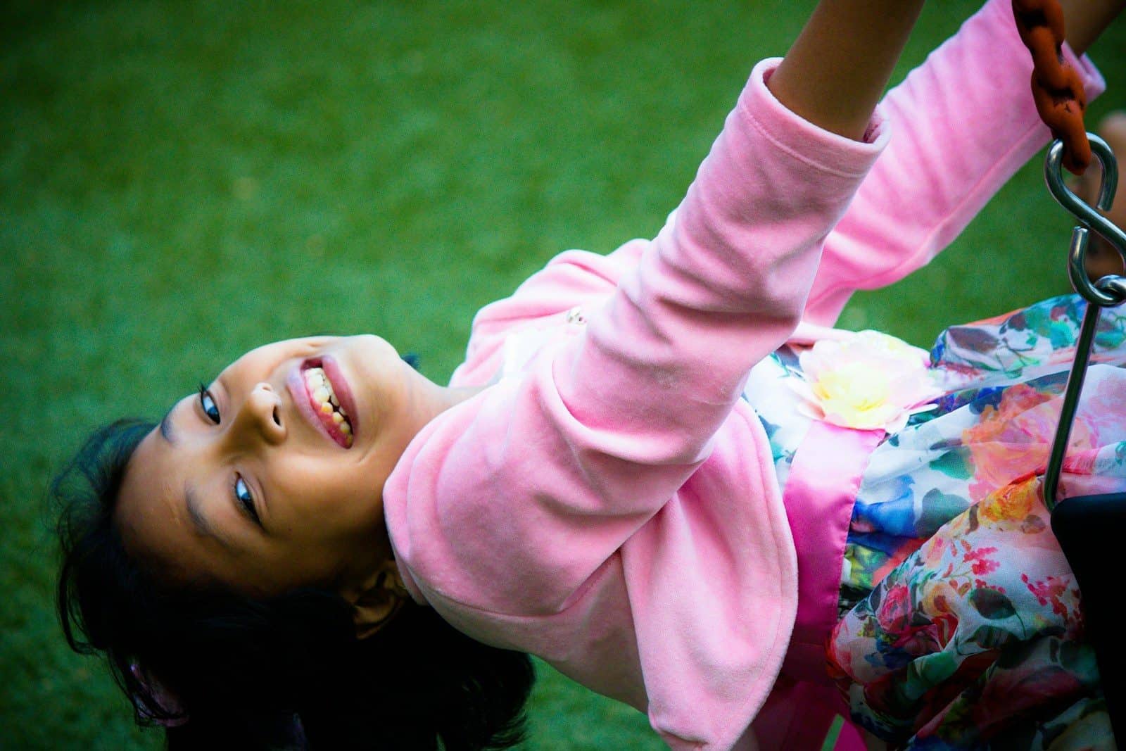 a little girl playing on a swing set